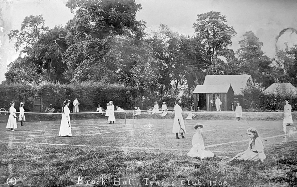A tennis court with girls playing and watching